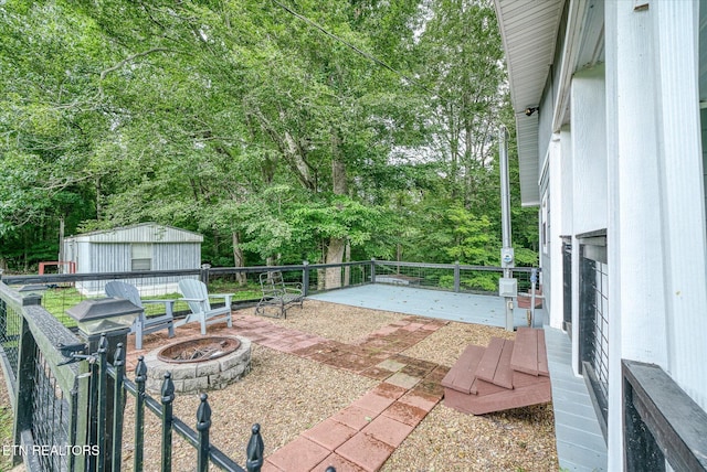 502 Midnight Dr, Byrdstown, TN 38549 - view of patio / terrace with an outdoor fire pit, an outdoor structure, view of scattered trees, and a deck