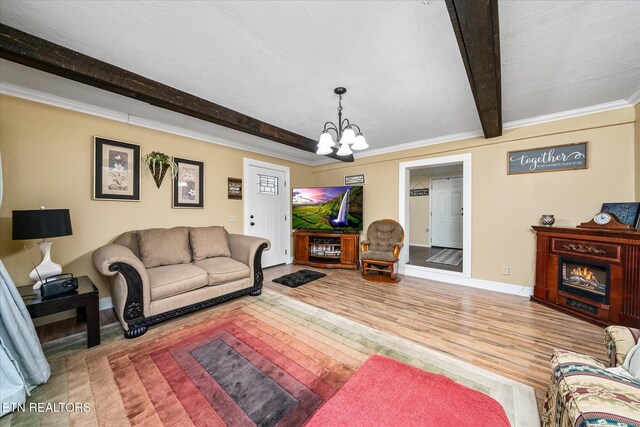 502 Midnight Dr, Byrdstown, TN 38549 - living room featuring a chandelier, beam ceiling, wood finished floors, a lit fireplace, and ornamental molding