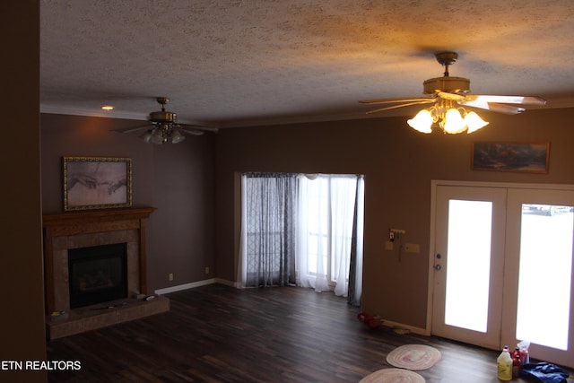 108 Laurel Dr, Jamestown, TN 38556 - unfurnished living room featuring a ceiling fan, a textured ceiling, wood finished floors, a tiled fireplace, and crown molding