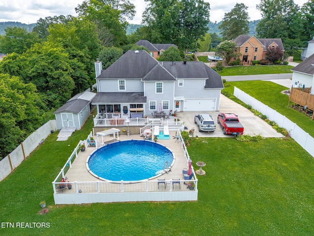 7110 Royal Springs Blvd, Knoxville, TN 37918 - rear view of house with a fenced backyard, a chimney, a wooden deck, a shingled roof, and an outdoor structure