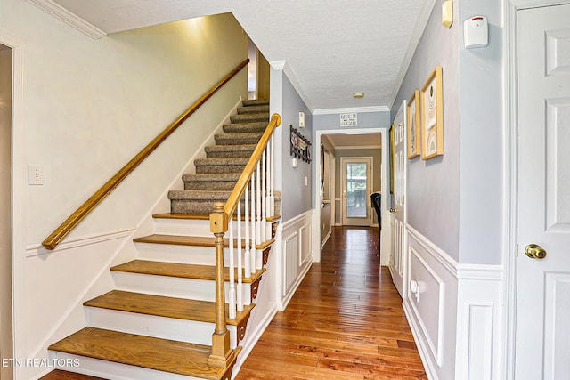 7110 Royal Springs Blvd, Knoxville, TN 37918 - stairway featuring wood finished floors, a wainscoted wall, crown molding, a textured ceiling, and a decorative wall
