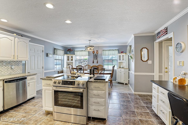 7110 Royal Springs Blvd, Knoxville, TN 37918 - kitchen with appliances with stainless steel finishes, decorative backsplash, a textured ceiling, white cabinets, and crown molding