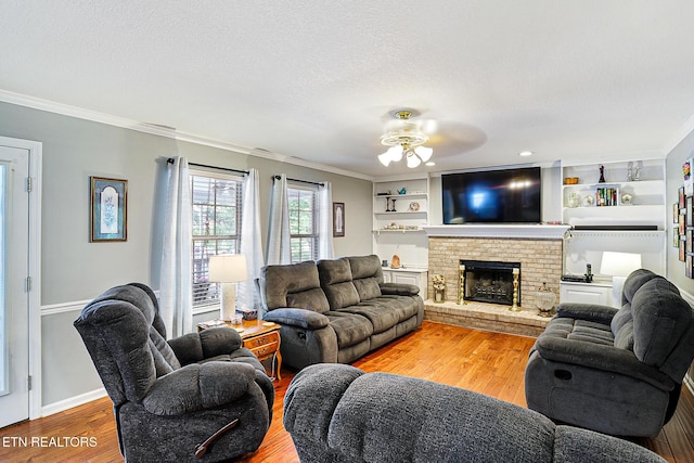 7110 Royal Springs Blvd, Knoxville, TN 37918 - living room with crown molding, ceiling fan, wood finished floors, a brick fireplace, and a textured ceiling