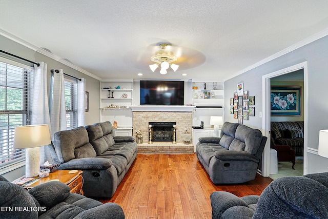 7110 Royal Springs Blvd, Knoxville, TN 37918 - living room with a ceiling fan, crown molding, light wood-style floors, a brick fireplace, and built in shelves