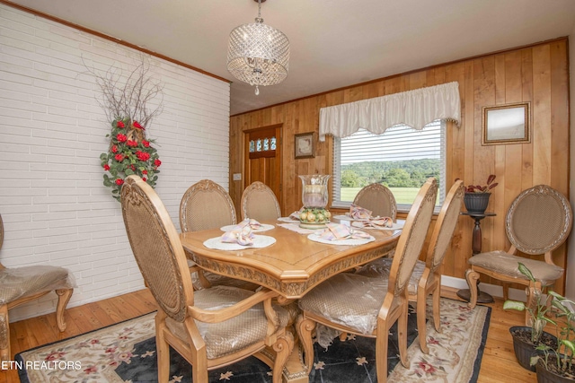 506 Blockhouse Valley Rd, Clinton, TN 37716 - dining space with wooden walls, brick wall, light wood-type flooring, and crown molding
