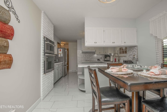 506 Blockhouse Valley Rd, Clinton, TN 37716 - kitchen with light countertops, white cabinets, tasteful backsplash, stainless steel appliances, and light marble finish floors