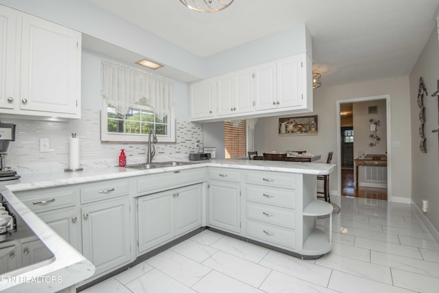 506 Blockhouse Valley Rd, Clinton, TN 37716 - kitchen featuring light marble finish floors, a peninsula, white cabinets, and backsplash