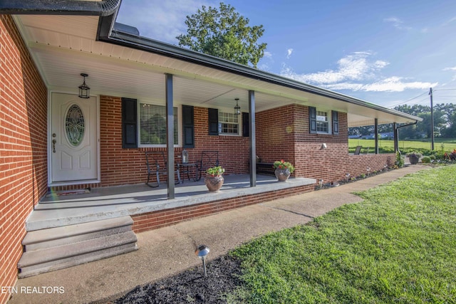 506 Blockhouse Valley Rd, Clinton, TN 37716 - doorway to property featuring covered porch, brick siding, and a yard