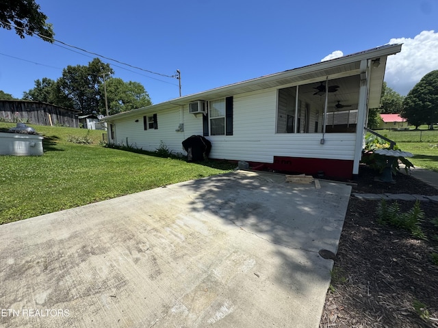 109 Henry Mayfield Rd, Tellico Plains, TN 37385 - view of front facade with ceiling fan, a front lawn, an AC wall unit, and a patio area
