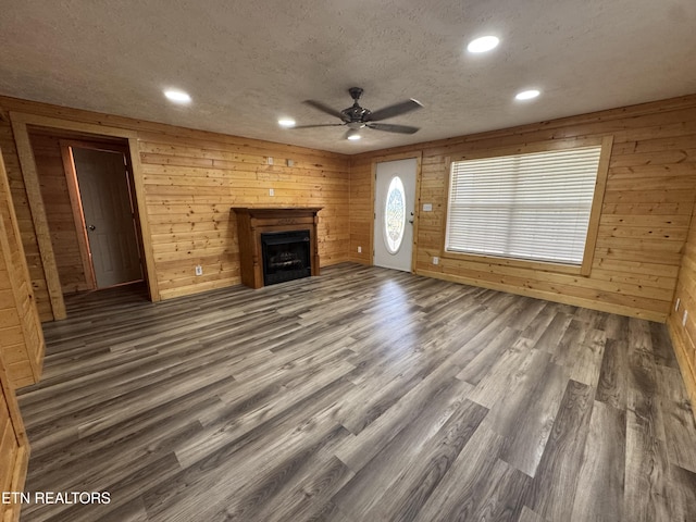 109 Henry Mayfield Rd, Tellico Plains, TN 37385 - unfurnished living room featuring a ceiling fan, wood finished floors, a fireplace, recessed lighting, and wood walls