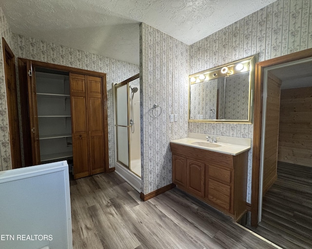 109 Henry Mayfield Rd, Tellico Plains, TN 37385 - full bath with wallpapered walls, wood finished floors, a textured ceiling, a stall shower, and vanity