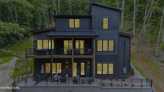 1646 Bear Valley Rd, Sevierville, TN 37876 - rear view of property featuring a balcony, a forest view, a metal roof, and a patio area