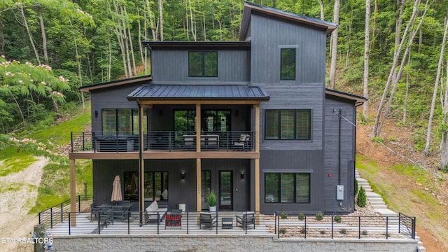 1646 Bear Valley Rd, Sevierville, TN 37876 - view of front of property featuring a balcony, a view of trees, a patio, and a metal roof