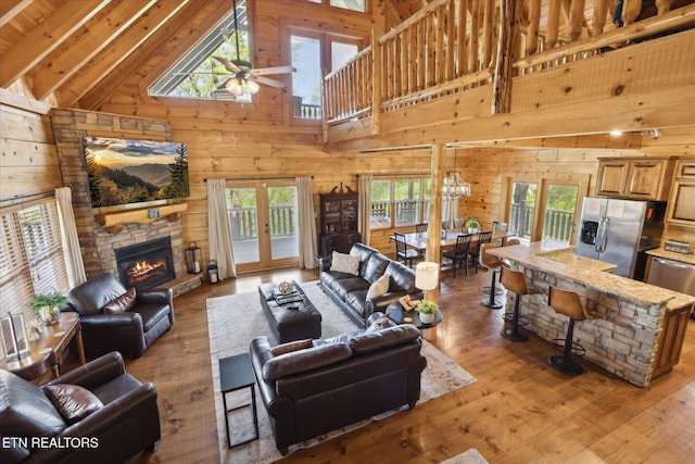 3206 Falling Leaf Way, Pigeon Forge, TN 37863 - living area featuring wooden walls, high vaulted ceiling, ceiling fan, healthy amount of natural light, and light wood finished floors