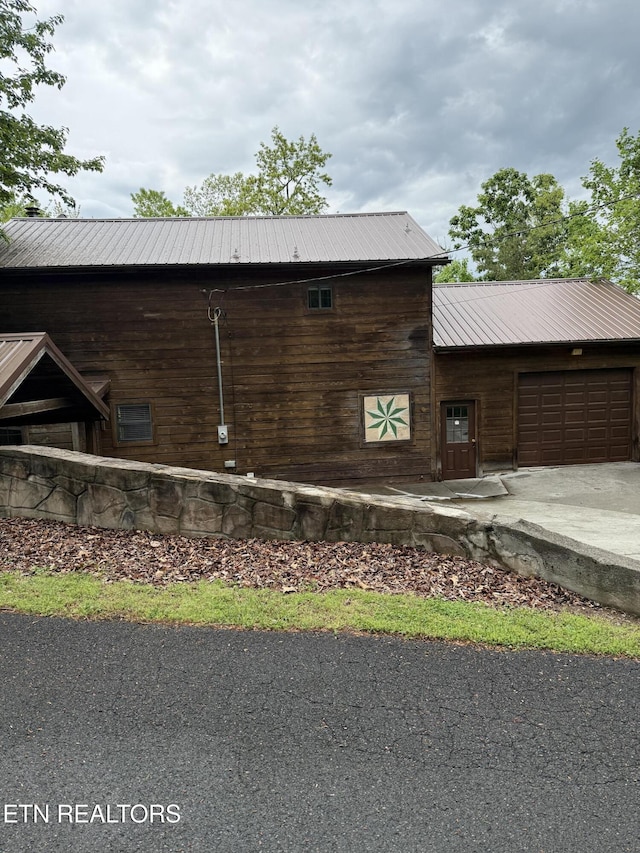 2006 Regans Ridge Way, Sevierville, TN 37876 - view of side of home with a garage, driveway, and a metal roof