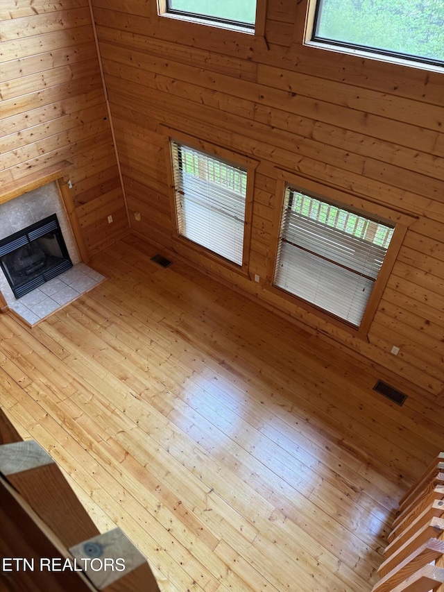 2006 Regans Ridge Way, Sevierville, TN 37876 - unfurnished living room with wooden walls, healthy amount of natural light, a tiled fireplace, and wood-type flooring