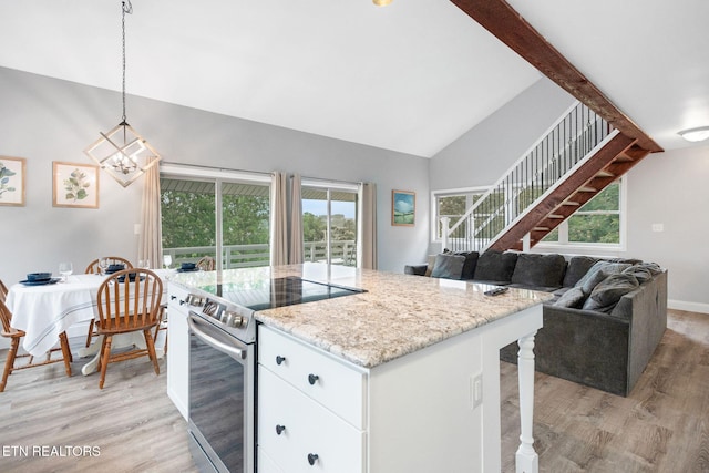 769 Gilmore Rd, Bean Station, TN 37708 - kitchen with stainless steel range with electric stovetop, light wood-style floors, white cabinets, high vaulted ceiling, and decorative light fixtures