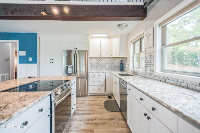 769 Gilmore Rd, Bean Station, TN 37708 - kitchen featuring stainless steel appliances, white cabinetry, light wood finished floors, and tasteful backsplash