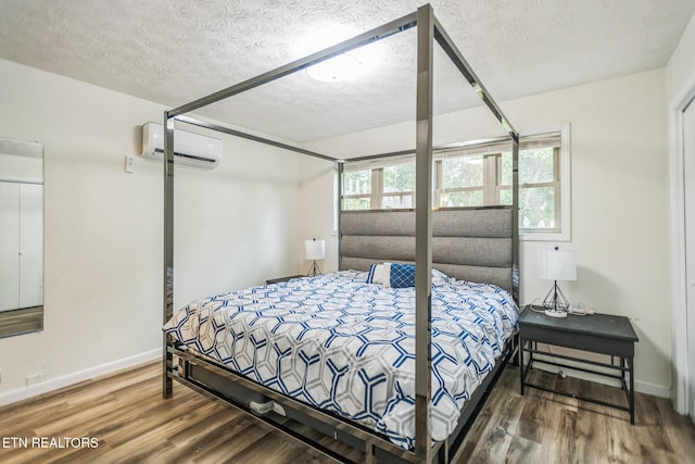 769 Gilmore Rd, Bean Station, TN 37708 - bedroom featuring a wall mounted AC, wood finished floors, and a textured ceiling