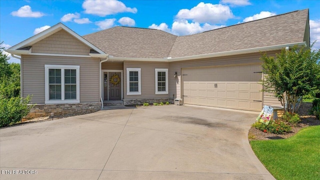 214 Unutsi Trl, Vonore, TN 37885 - view of front of home with concrete driveway, a garage, a shingled roof, and stone siding