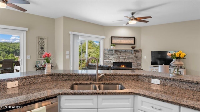 214 Unutsi Trl, Vonore, TN 37885 - kitchen featuring a ceiling fan, dark stone countertops, white cabinets, a fireplace, and stainless steel dishwasher