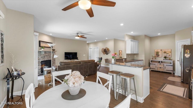 214 Unutsi Trl, Vonore, TN 37885 - dining area featuring ceiling fan, dark wood finished floors, a stone fireplace, and recessed lighting