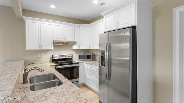 214 Unutsi Trl, Vonore, TN 37885 - kitchen with stainless steel appliances, under cabinet range hood, light stone counters, white cabinetry, and recessed lighting