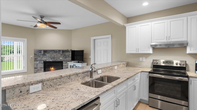 214 Unutsi Trl, Vonore, TN 37885 - kitchen with stainless steel appliances, under cabinet range hood, a ceiling fan, a fireplace, and white cabinets
