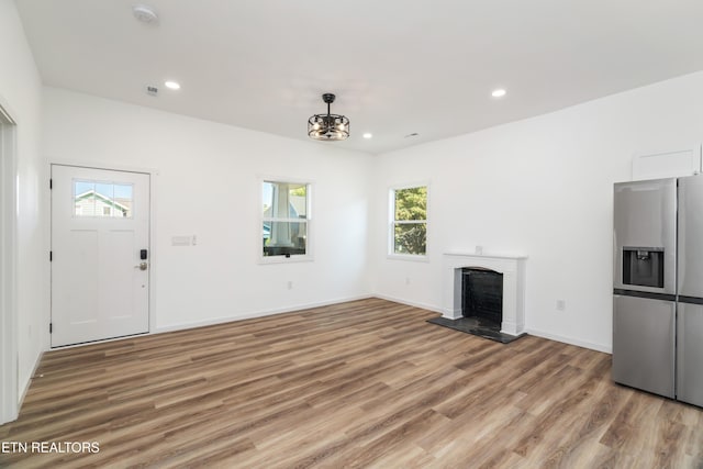2824 Linden Ave, Knoxville, TN 37914 - unfurnished living room with light wood-type flooring, plenty of natural light, recessed lighting, and a fireplace with raised hearth