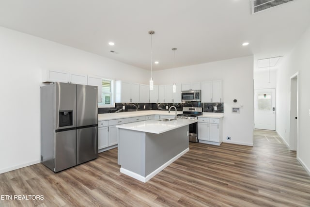 2824 Linden Ave, Knoxville, TN 37914 - kitchen featuring appliances with stainless steel finishes, wood finished floors, light countertops, white cabinetry, and tasteful backsplash