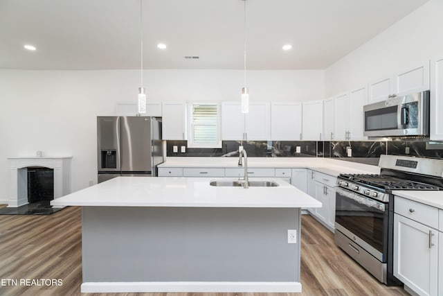 2824 Linden Ave, Knoxville, TN 37914 - kitchen featuring appliances with stainless steel finishes, backsplash, light countertops, wood finished floors, and white cabinets