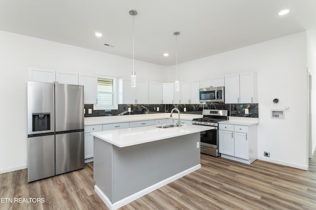 2824 Linden Ave, Knoxville, TN 37914 - kitchen featuring stainless steel appliances, wood finished floors, light countertops, white cabinets, and backsplash