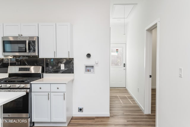 2824 Linden Ave, Knoxville, TN 37914 - kitchen with stainless steel appliances, light wood finished floors, backsplash, white cabinetry, and light countertops