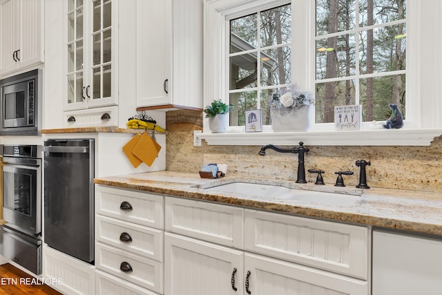 453 Mount John Loop, Townsend, TN 37882 - kitchen featuring appliances with stainless steel finishes, glass insert cabinets, white cabinetry, a warming drawer, and backsplash