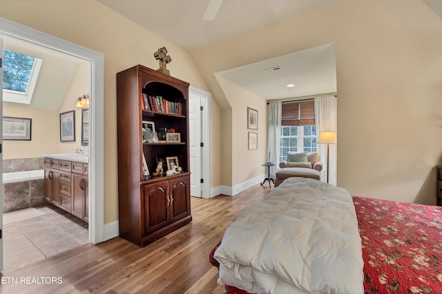 453 Mount John Loop, Townsend, TN 37882 - bedroom featuring a skylight, light wood-style flooring, vaulted ceiling, ensuite bath, and ceiling fan