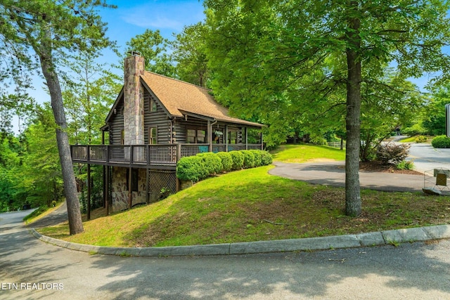 664 Kings Hills Blvd, Pigeon Forge, TN 37863 - view of home's exterior with a deck, log exterior, a lawn, a chimney, and stone siding