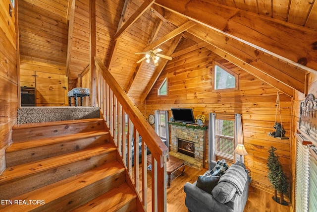 664 Kings Hills Blvd, Pigeon Forge, TN 37863 - staircase with wooden walls, wood ceiling, wood finished floors, a stone fireplace, and a ceiling fan