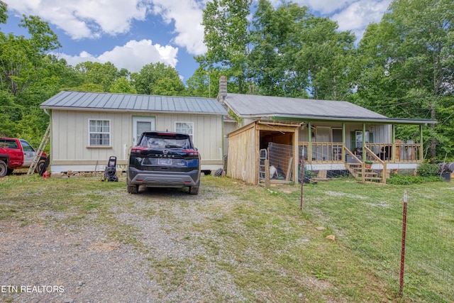 5271 Vardy Blackwater Rd, Sneedville, TN 37869 - view of front of house featuring board and batten siding, a metal roof, a porch, a chimney, and a front lawn