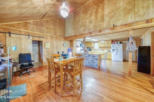 5271 Vardy Blackwater Rd, Sneedville, TN 37869 - dining area featuring high vaulted ceiling, light wood-style floors, a barn door, and wood walls