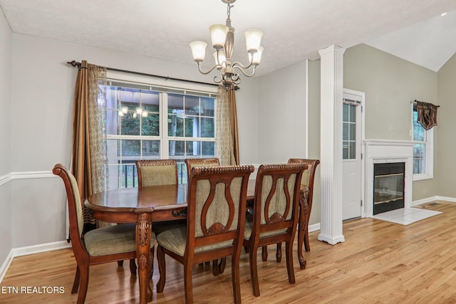 317 Fallen Oak Cir, Seymour, TN 37865 - dining room with light wood finished floors, a chandelier, a tiled fireplace, and a textured ceiling