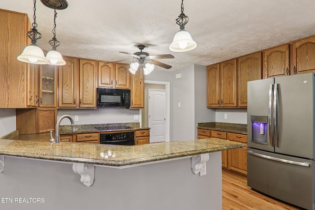 317 Fallen Oak Cir, Seymour, TN 37865 - kitchen with black appliances, brown cabinets, a peninsula, and a textured ceiling