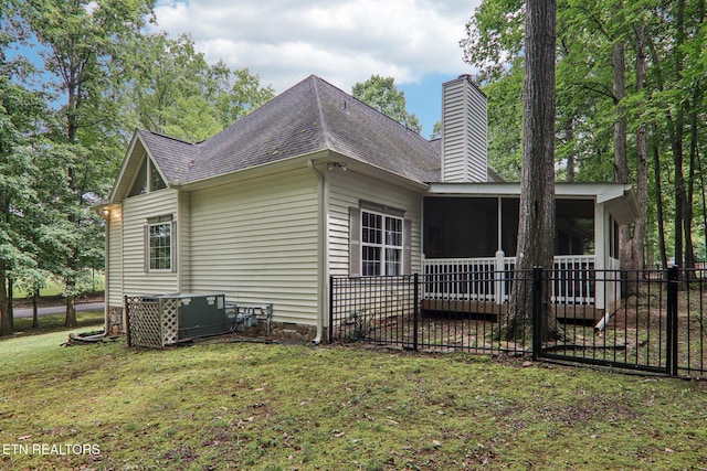 317 Fallen Oak Cir, Seymour, TN 37865 - view of home's exterior featuring a sunroom, a shingled roof, and a chimney