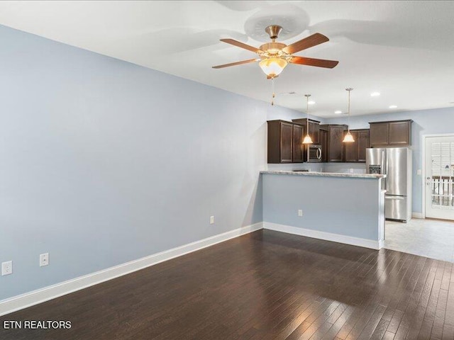 2415 Flannery Way, Powell, TN 37849 - kitchen with stainless steel appliances, dark brown cabinets, a ceiling fan, dark wood finished floors, and a peninsula