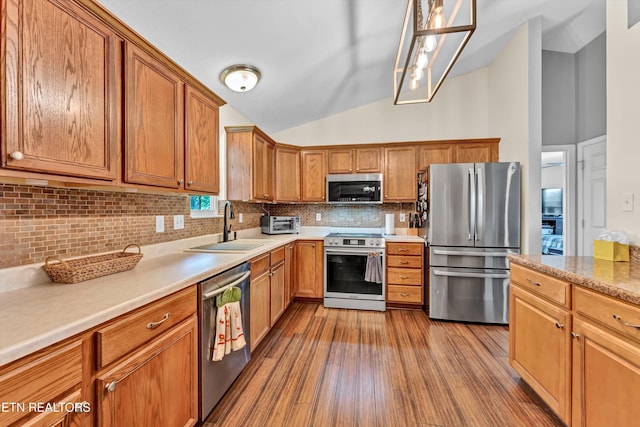 6718 Farmbrook Ln, Knoxville, TN 37918 - kitchen with stainless steel appliances, vaulted ceiling, backsplash, wood finished floors, and light countertops