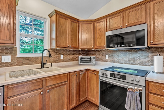 6718 Farmbrook Ln, Knoxville, TN 37918 - kitchen with stainless steel appliances, light countertops, backsplash, brown cabinets, and vaulted ceiling
