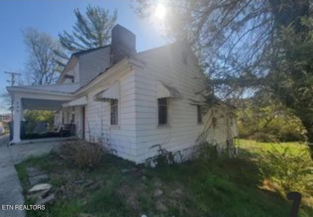 139 W Meeting St, Dandridge, TN 37725 - view of side of property featuring a chimney and a carport