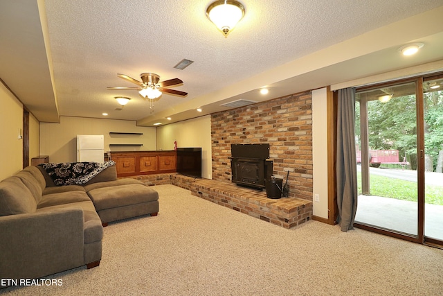 433 Clover Fork Dr, Knoxville, TN 37934 - living room featuring carpet flooring, a textured ceiling, a ceiling fan, and a wood stove