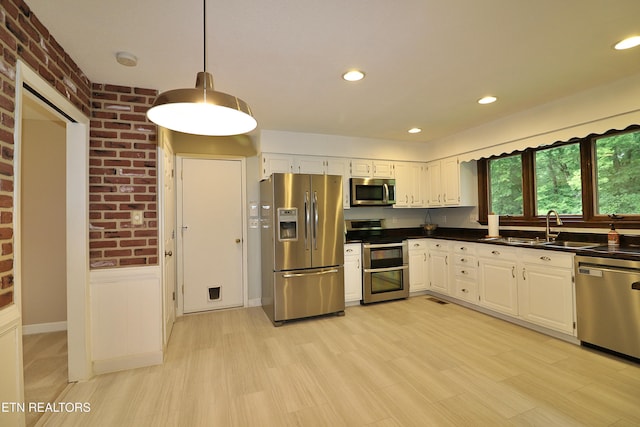 433 Clover Fork Dr, Knoxville, TN 37934 - kitchen featuring appliances with stainless steel finishes, dark countertops, white cabinets, decorative light fixtures, and brick wall