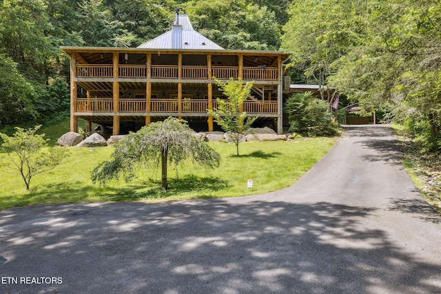 3014 N Clear Fork Rd, Sevierville, TN 37862 - log cabin with a forest view, a metal roof, a deck, and a front lawn