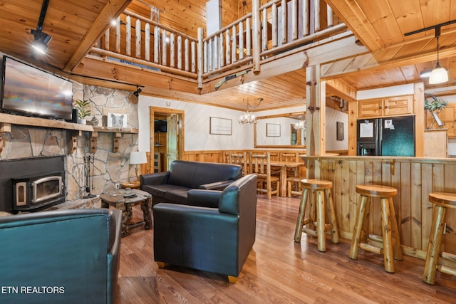 3014 N Clear Fork Rd, Sevierville, TN 37862 - living room with wood walls, a wooden ceiling with exposed beams, a wood stove, wood finished floors, and bar